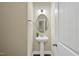 Stylish half bathroom features a pedestal sink, oval mirror, and elegant lighting fixtures at 707 Newlyn Dr, Raleigh, NC 27606