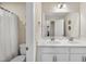 Bright bathroom featuring a double sink vanity with white cabinets and a framed mirror at 707 Newlyn Dr, Raleigh, NC 27606