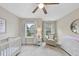 Bedroom with neutral walls, white carpet, a crib, and natural light, creating a calm and inviting atmosphere at 707 Newlyn Dr, Raleigh, NC 27606