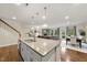 Spacious open floor plan with granite island, stainless sink, and view of living room and dining area at 707 Newlyn Dr, Raleigh, NC 27606