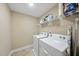 Clean and organized laundry room with tile floors, washer, dryer and shelving for storage at 707 Newlyn Dr, Raleigh, NC 27606