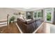 Comfortable living room with stone fireplace, brown leather sectional, and bright, natural light at 707 Newlyn Dr, Raleigh, NC 27606