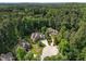 Stunning aerial view of a large estate nestled among mature trees with circular driveway and professionally landscaped yard at 71012 Russell, Chapel Hill, NC 27517