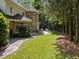 Lush backyard featuring stone pathway, patio with seating, and mature trees offering privacy at 71012 Russell, Chapel Hill, NC 27517