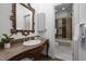 Bathroom vanity with granite countertop, decorative mirror, and access to tiled shower and bath at 71012 Russell, Chapel Hill, NC 27517