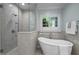 Bright bathroom showcasing a soaking tub beneath a window and a tiled glass-enclosed shower at 71012 Russell, Chapel Hill, NC 27517