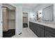 Bathroom featuring a double sink vanity with gray cabinets and marble countertops and access to walk-in closets at 71012 Russell, Chapel Hill, NC 27517