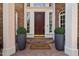 Inviting front entrance with a dark wood door, brick steps, and decorative plants at 71012 Russell, Chapel Hill, NC 27517