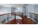 Elegant upper hallway features hardwood floors and ornate wrought iron railings overlooking the foyer below at 71012 Russell, Chapel Hill, NC 27517