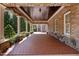 Extensive covered patio with brick flooring, stone accents, and white columns at 71012 Russell, Chapel Hill, NC 27517