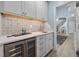 Elegant wet bar includes a beverage cooler, sink, and tiled backsplash, perfect for entertaining at 71012 Russell, Chapel Hill, NC 27517