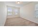 Well-lit bedroom featuring three windows, neutral carpet, and light-colored walls at 72 S Grey Abbey Dr, Clayton, NC 27527