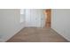 Bright bedroom with neutral carpet, a window with blinds, and a white door at 72 S Grey Abbey Dr, Clayton, NC 27527