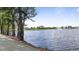 Picturesque lake view with mature trees lining the paved path at 72 S Grey Abbey Dr, Clayton, NC 27527