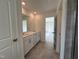 A bathroom with dual sinks and a shower with glass doors, leading into a carpeted room at 753 Swim Cave Ln, Wendell, NC 27591
