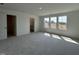 Bright bedroom with plush carpeting, three large windows, and a peek into the ensuite bathroom at 753 Swim Cave Ln, Wendell, NC 27591