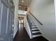 Bright entryway featuring a staircase with dark wood treads and black metal railing at 753 Swim Cave Ln, Wendell, NC 27591