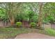 Serene backyard featuring mature trees and an iron fence that defines the landscape at 8013 Morrell Ln, Durham, NC 27713