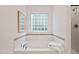 This bathroom features a large soaking tub with tile accents and a window allowing plenty of natural light at 8013 Morrell Ln, Durham, NC 27713