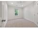 This bedroom has neutral carpet, a window, and a ceiling fan at 8013 Morrell Ln, Durham, NC 27713