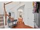 Open foyer with wood floors, staircase, and view into the living room with a fireplace at 8013 Morrell Ln, Durham, NC 27713