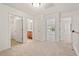 Neutral upstairs hallway featuring several doors to other rooms and a light-filled area at 8013 Morrell Ln, Durham, NC 27713