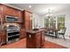 Modern kitchen featuring stainless steel appliances and elegant cabinetry, open to a bright dining space at 8013 Morrell Ln, Durham, NC 27713