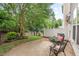 Cozy outdoor patio with mature trees, a small table set, and a peaceful, fenced-in backyard at 8013 Morrell Ln, Durham, NC 27713