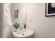 Stylish powder room featuring a pedestal sink, modern fixtures, and a decorative oval mirror at 8013 Morrell Ln, Durham, NC 27713