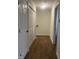 Hallway with wood look floors and closet, leading to stairs and an open doorway at 805 Da Vinci St, Durham, NC 27704