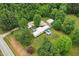 An aerial view of a single story home with a metal roof, a long drive, and a detached garage at 8089 Crawford Currin Rd, Oxford, NC 27565