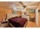 Cozy log-walled bedroom with a ceiling fan and a plaid comforter on the bed at 8089 Crawford Currin Rd, Oxford, NC 27565