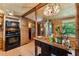 Rustic kitchen features wood paneled walls, wooden cabinets, modern appliances and an ornate hanging light fixture at 8089 Crawford Currin Rd, Oxford, NC 27565