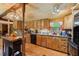 Spacious rustic kitchen with wooden cabinets and panels, black appliances and hardwood floors at 8089 Crawford Currin Rd, Oxford, NC 27565