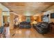 Cozy living room with wood paneled walls, hardwood floors, and comfortable leather sofas at 8089 Crawford Currin Rd, Oxford, NC 27565