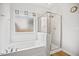 Bathroom showcasing a glass-enclosed shower, tub, and frosted window for privacy at 95 Buckthorn Dr, Youngsville, NC 27596