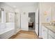 Bright bathroom features a tub, glass-enclosed shower, and a door to the main bedroom at 95 Buckthorn Dr, Youngsville, NC 27596