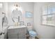 Clean bathroom with an oval mirror, modern vanity, and a bright window for natural lighting at 95 Buckthorn Dr, Youngsville, NC 27596