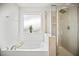 Bathroom with separate shower and bath, frosted window, and large garden tub at 95 Buckthorn Dr, Youngsville, NC 27596