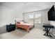 Bright bedroom featuring carpeted floors, white walls and trim, a bed, a nightstand, and a wall-mounted television at 95 Buckthorn Dr, Youngsville, NC 27596