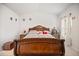 This bedroom features a decorative wooden bed frame, carpet floors, and neutral decor at 95 Buckthorn Dr, Youngsville, NC 27596