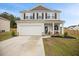 Charming two-story home with gray siding, black shutters, landscaped yard, and a two-car garage at 95 Buckthorn Dr, Youngsville, NC 27596
