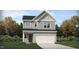 Charming two-story home with gray siding, a two-car garage, and a landscaped front yard at 100 Fishing Pier Way, Lillington, NC 27546