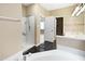 Bright bathroom featuring a step-in shower, black tile floor, and a separate sink at 1005 Augustine Trl, Cary, NC 27518