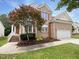 Charming brick home with a well-manicured lawn, mature landscaping, and attached two-car garage at 1005 Augustine Trl, Cary, NC 27518