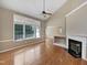 Cozy living room with a fireplace, hardwood floors, and large windows for natural light at 1005 Augustine Trl, Cary, NC 27518