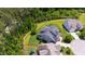 Aerial view of a gray house with a beautiful backyard, mature trees, and neighboring houses at 102 Bella Rose Drive, Chapel Hill, NC 27517