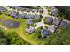Aerial view showcasing a neighborhood with well-manicured lawns, a pond, and mature trees at 102 Bella Rose Drive, Chapel Hill, NC 27517