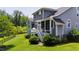 Rear exterior view showcasing the home's siding, screened-in porch, deck and landscaped backyard at 102 Bella Rose Drive, Chapel Hill, NC 27517