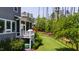 Backyard view showcasing the screened-in porch, lush lawn, mature trees, and play set at 102 Bella Rose Drive, Chapel Hill, NC 27517